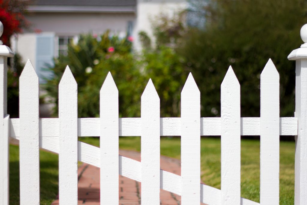 white picket fence gate on a wooden fence installation