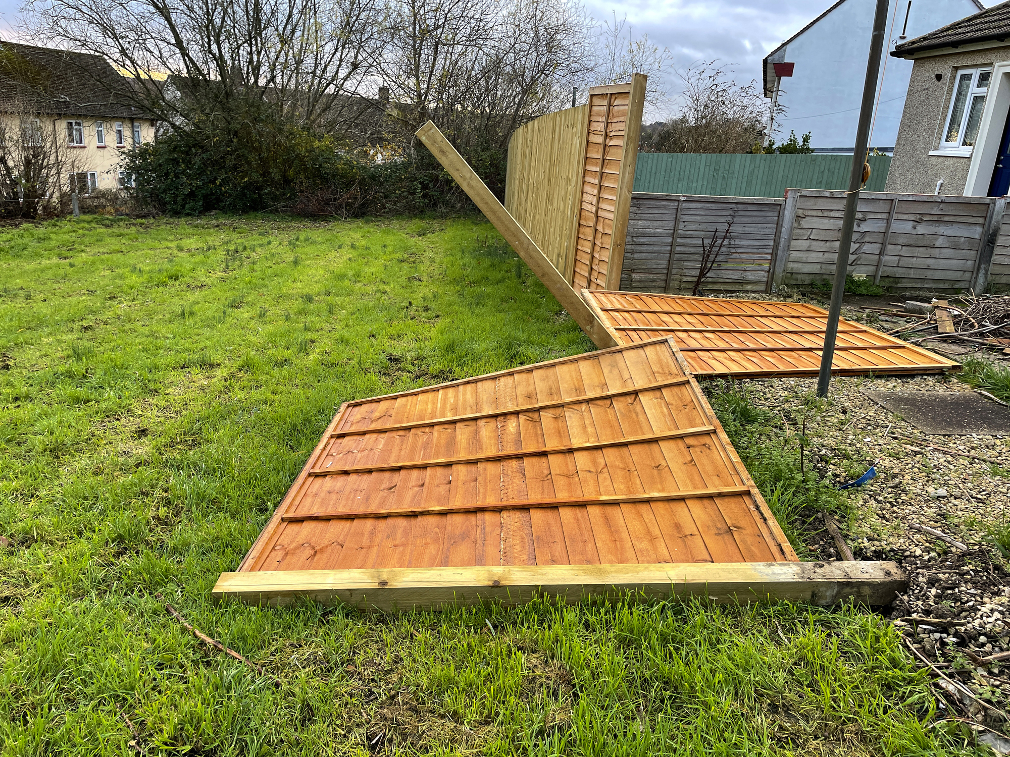 Image of fallen garden fence panels blown over by wind